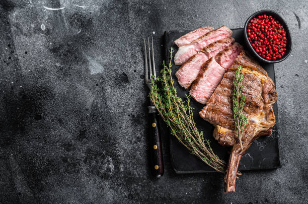istock Grilled Tomahawk Beef Steak, Rib eye with thyme. Black background. Top view. Copy space 1370938229