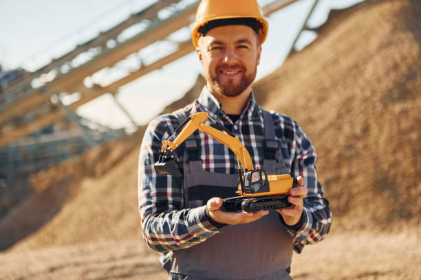 istock Holding toy. Construction worker in uniform is on the quarry 1370938347