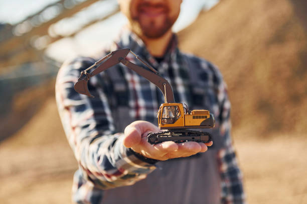 istock Holding toy. Construction worker in uniform is on the quarry 1370938379