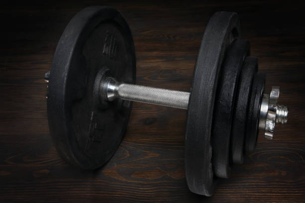 istock Black dumbbell on dark wooden background 1370938473
