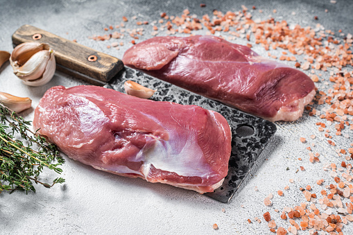Fresh Raw Duck breast, fillet,  poultry meat on butcher cleaver. White background. Top view.