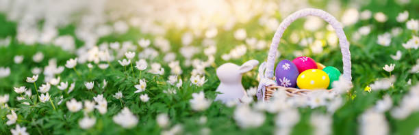 istock Panoramic view of the spring field with rabbit toy and bascket with colourful eggs on it. 1370938647