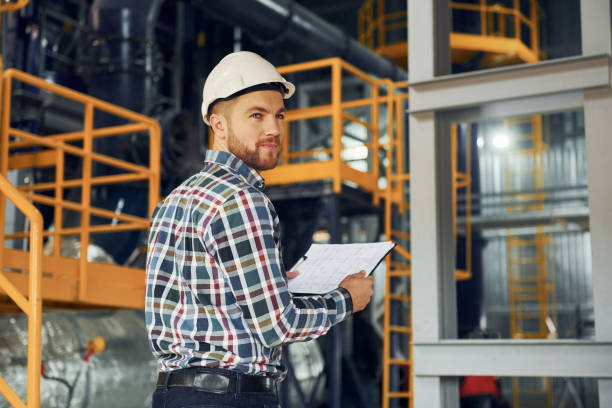 istock Engineer is indoors. Construction worker in uniform is in the factory 1370938760