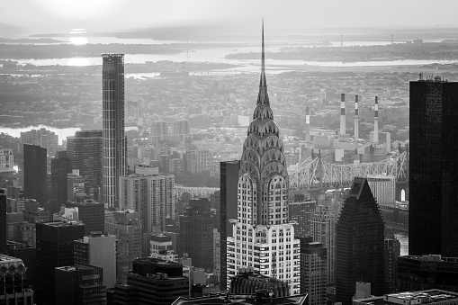 Black and white photo of the Chrysler Building lights up at dawn, right before the rest of the city awakens.