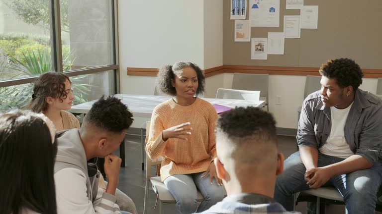 Vulnerable teenage girl talks during teen support group meeting