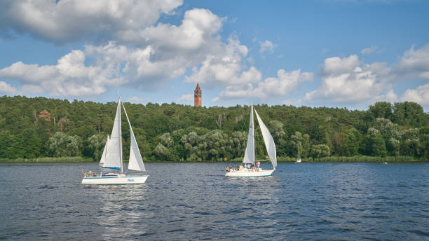 Sailboats on the river Havel near Berlin, in the background the Grunewaldturm Berlin, Germany – July 17, 2021: Sailboats on the river Havel near Berlin, in the background the Grunewaldturm on the Karlsberg mountain grunewald berlin stock pictures, royalty-free photos & images