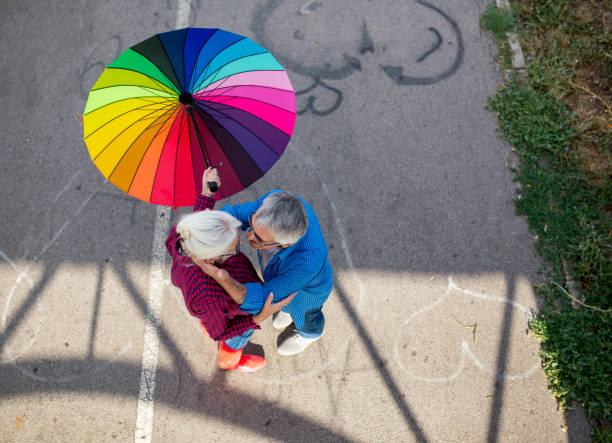 The old couple in the rain with umbrellas