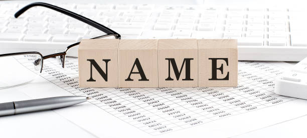 istock NAME written on wooden cube with keyboard , calculator, chart,glasses.Business concept 1370951684