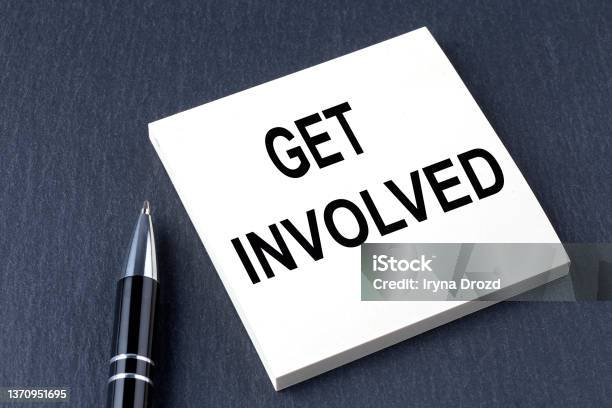Get Involved Text On The Sticker With Pen On Black Background Stock Photo - Download Image Now