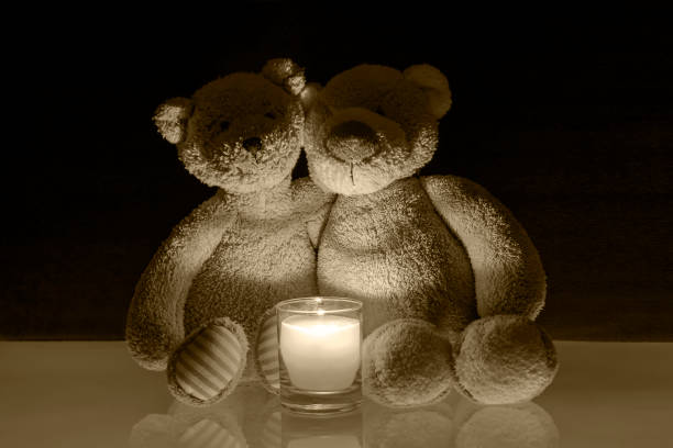 istock Two teddy bears with burning candle 1370951953