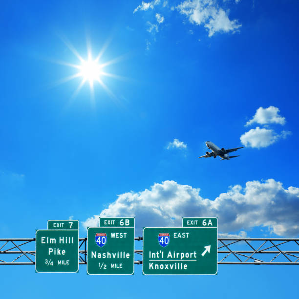 concepto de viaje de señalización de autopista y avión volador sobre cielo azul soleado - copy space road sign sky above fotografías e imágenes de stock