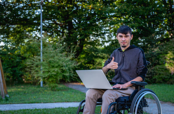 istock A real disabled person in a wheelchair communicates with the world through electronic devices, computer, telephone 1370953643