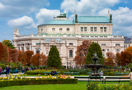 Vienna, Austria - October 2021: Fountain in Volksgarten park with Burg theater at background