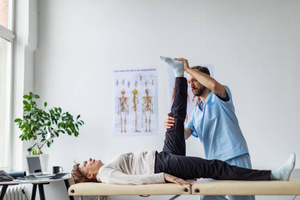 istock Physical therapist helping senior woman with exercise for legs 1370957257