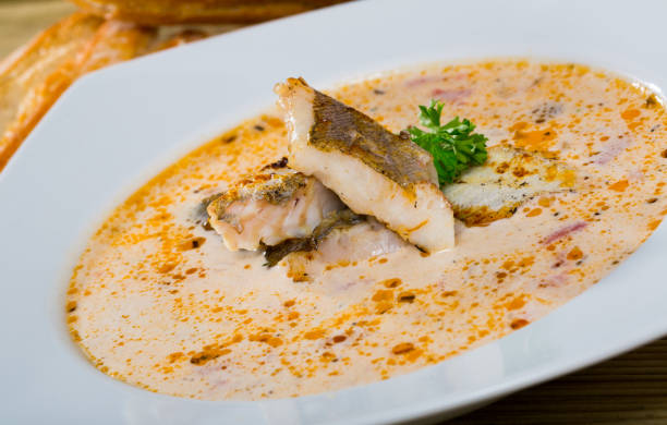 tasty soup with white fish pollock and greens at white plate - pollock trawler imagens e fotografias de stock