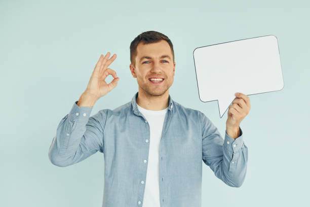 istock Smiling and having good mood. Man standing in the studio with empty signs for the text 1370967535