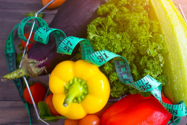 istock fresh vegetables, measuring tape on wooden background 1370968149