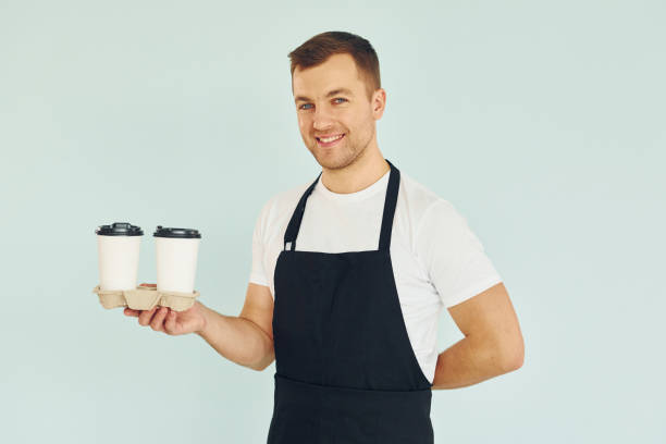 istock Man in uniform standing in the studio with drinks in hands 1370969040