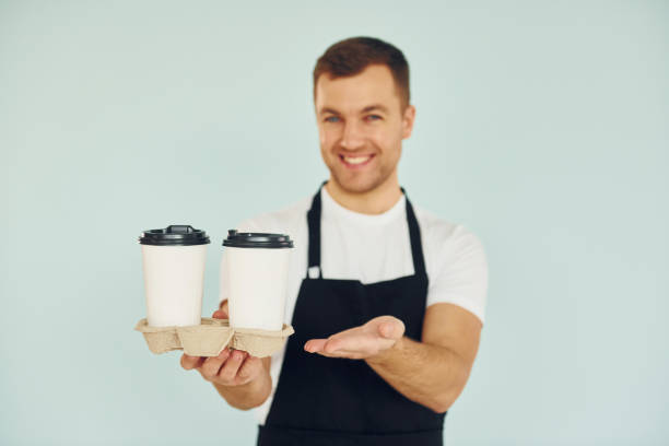 istock Man in uniform standing in the studio with drinks in hands 1370969041