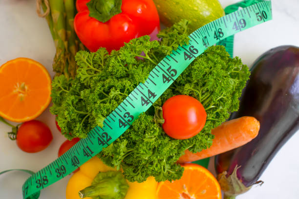 istock fresh vegetables, measuring tape on wooden background 1370969160