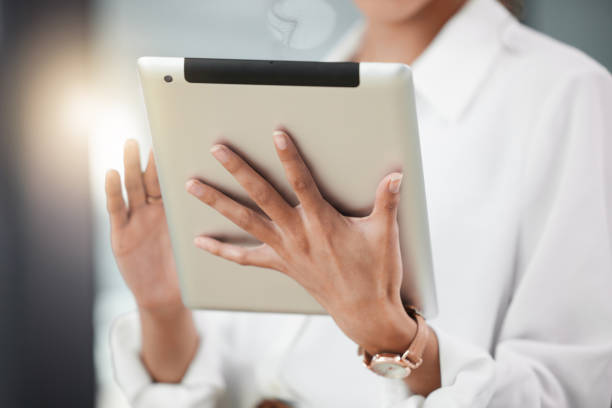 istock Shot of a young businesswoman using a digital tablet while standing in her office 1370972093