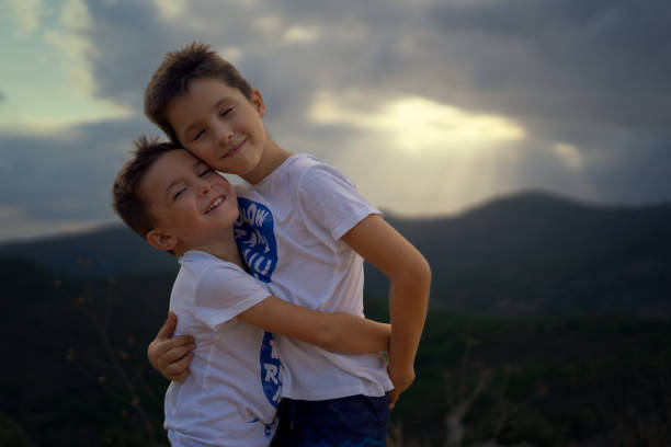 istock two brothers lovingly embracing each other with a summer sunset in the background 1370974036