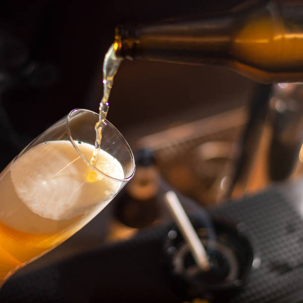 istock bartender pour beer to the glass from bottle 1370975330