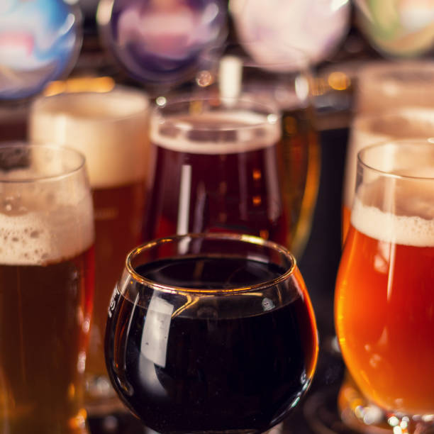 портер темное пиво на деревянном столе - hard liquor color image photography brewery стоковые фото и изображения