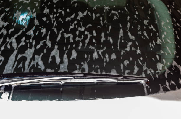 istock White foam on rear window of white car in open garage 1370978144