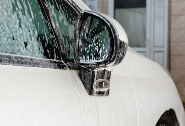 istock White foam on side mirror of white car in open garage 1370978148