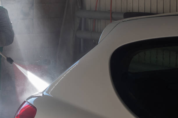 istock Washing white car with water jet in garage 1370978159