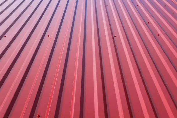 Photo of Red sheeting on the roof. Close-up. Vertical view. Background. Texture.