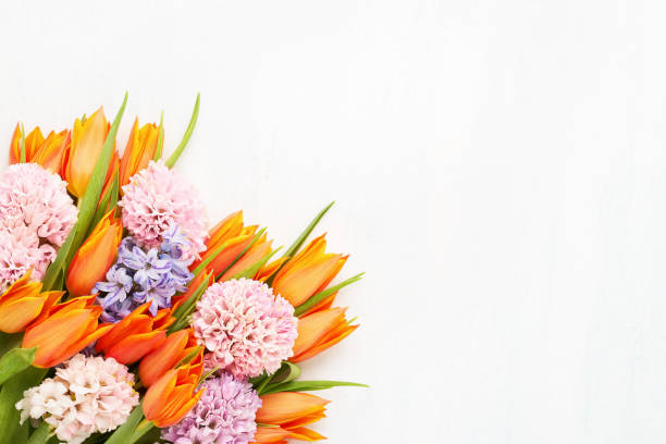 明るいオレンジ色のチューリップとピンクのヒヤシンスの花が明るい背景に束ねています。フラットレイ、コピースペース - flower arrangement ストックフォトと画像