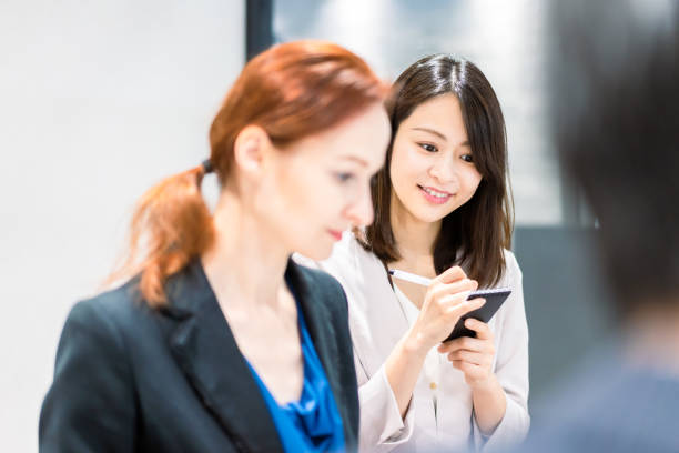 una donna straniera che parla a una conferenza con il suo interprete - connect parola inglese foto e immagini stock