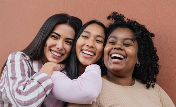 カメラの前で抱き合い、微笑む幸せな多民族の友人の肖像画 - university freshman portrait teenager ストックフォトと画像