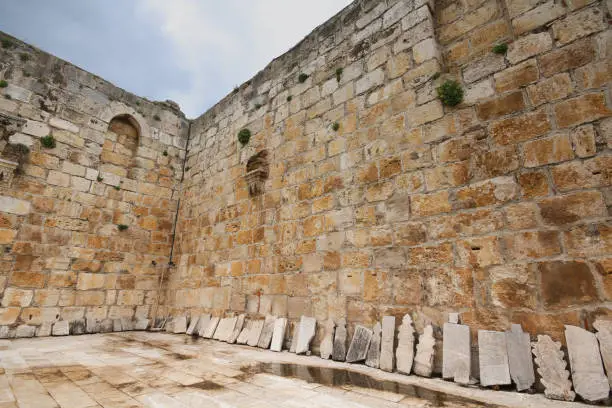 Photo of Ancient tombstones leaning against the courtyard wall of Isa Bey Mosque in Selcuk