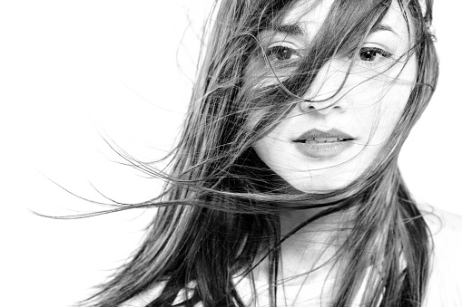 black and white high key portait of a girl with long windy hair