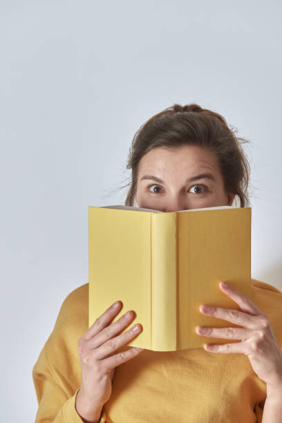 istock A beautiful, mysterious woman with a yellow book. 1370984016