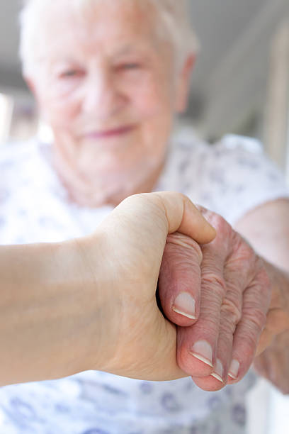 istock caregiver holding senior woman's hand 137098426