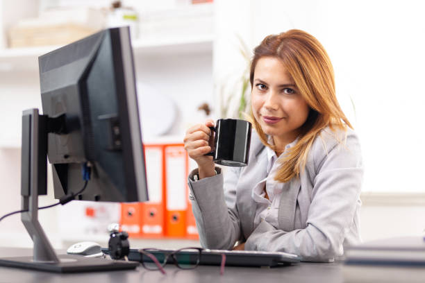 istock business woman with a cup in an office 1370993641
