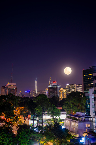 Ho Chi Minh city, Vietnam - 16 Feb 2022: Landmark 81 Skyscraper and many buildings, view from district 1 in Ho Chi Minh city, Vietnam. Beautiful landscape with full moon on night sky.