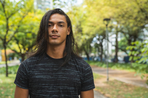 Portrait of hispanic man outdoors portrait, hispanic man, outdoors, serious face, one person gay long hair stock pictures, royalty-free photos & images