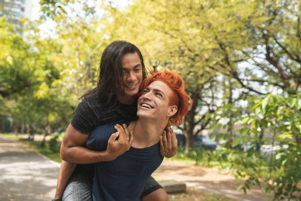 Gay man carrying his boyfriend on his shoulders stock photo