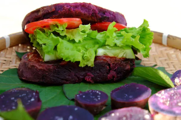 Amazing vegan hamburger from violet sweet potato with tomato, salad, healthy food for breakfast that rich starch, fiber