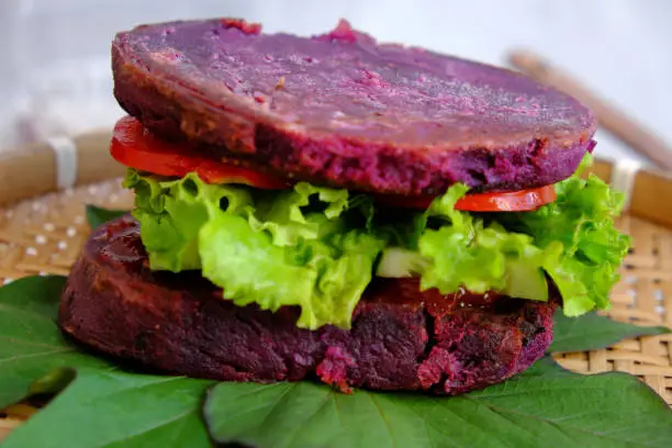 Amazing vegan hamburger from violet sweet potato with tomato, salad, healthy food for breakfast that rich starch, fiber
