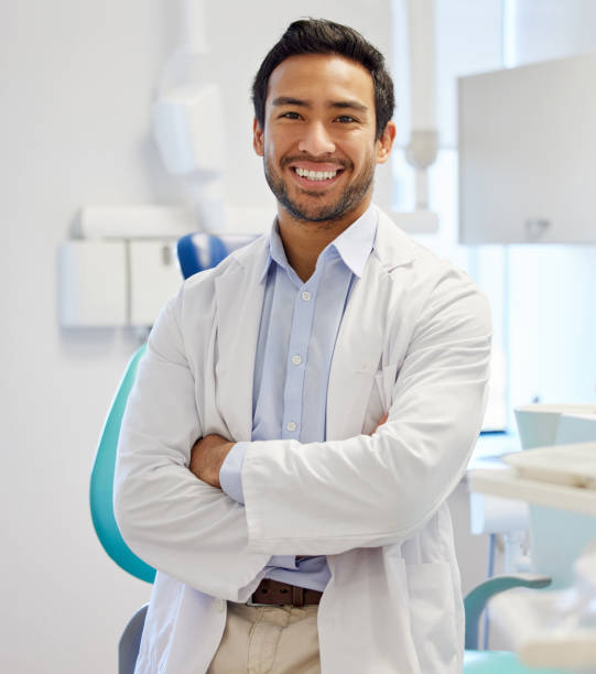 porträt eines selbstbewussten jungen zahnarztes in seinem sprechzimmer - zahnarzt stock-fotos und bilder