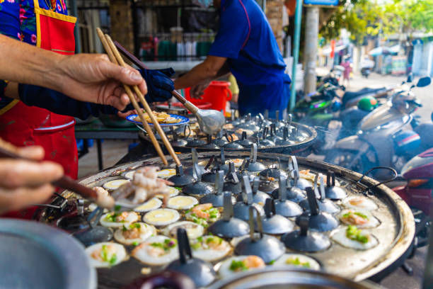 Vietnamese savory mini shrimp pancakes (Banh Khot) with herbs, eggs, shrimps and fish Sauce - Vietnamese cuisine. Selective focus. Food and travel concept.