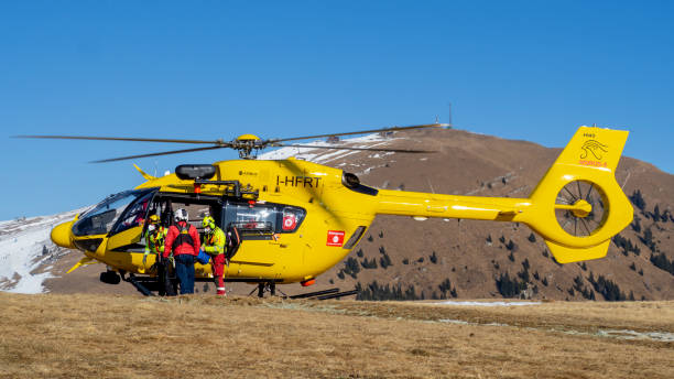 rettungshubschrauber über den bergen, um wanderern zu helfen. erste-hilfe-hubschrauber. team bereit für notfallmaßnahmen. medizinischer rettungshubschrauber am boden - rescue mountain horizontal three people stock-fotos und bilder