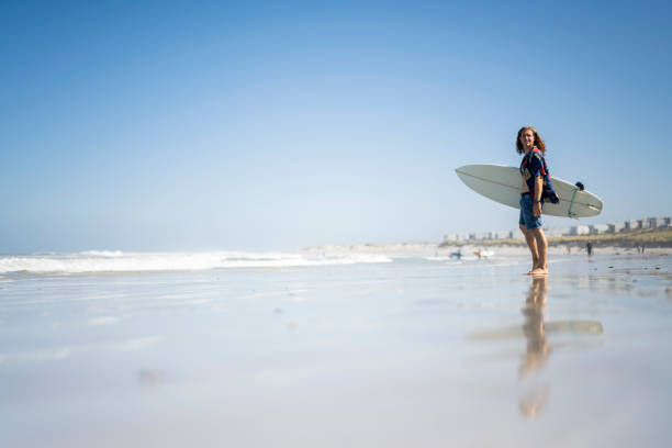 Reflection of surfer on beach loking for waves