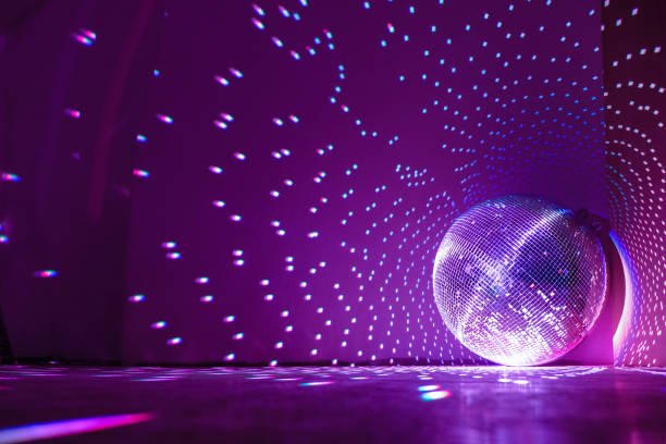 palla da discoteca che riflette la luce viola in una sala buia per discoteche. concetto di vacanze. spazio di copia. - palla da discoteca foto e immagini stock